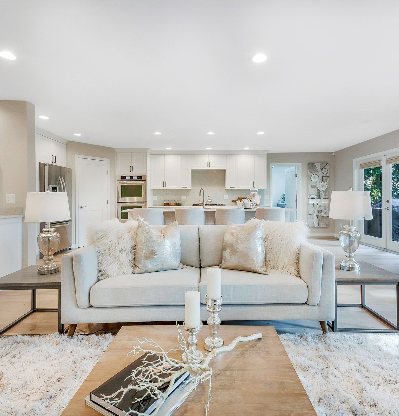 A contemporary open-concept living room and kitchen are shown from a head-on perspective.