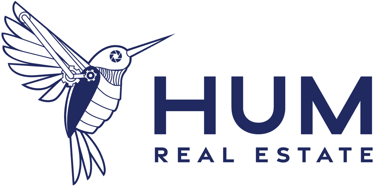 The logo of HUM Real Estate featuring a stylized blue hummingbird on a transparent background.