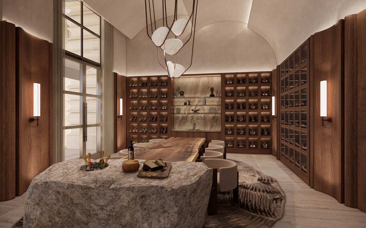 Luxury wine room with dark wood bottle cabinets, a long dining table, and a sculptural pendant.