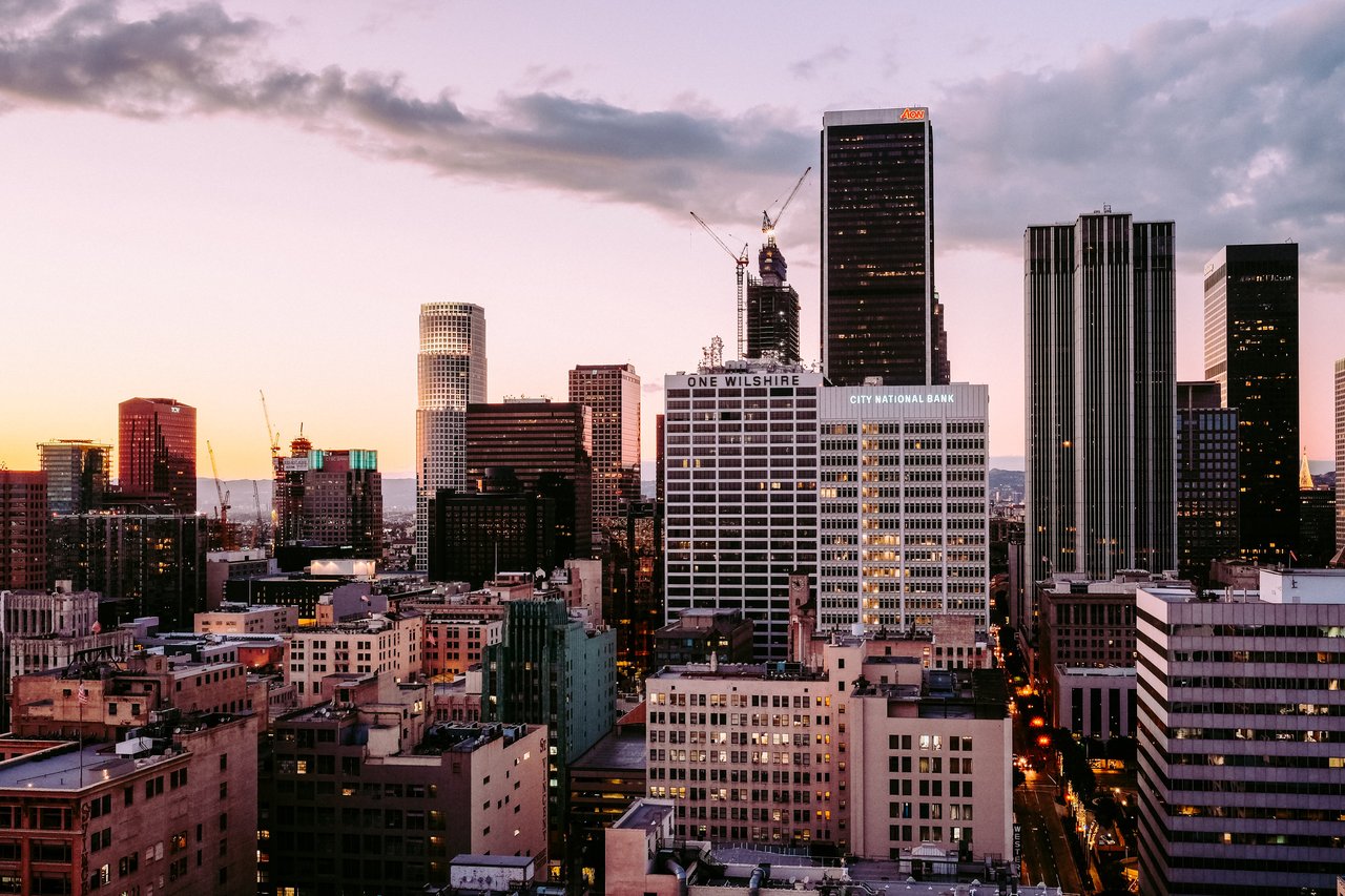 Downtown Los Angeles skyline at sunset, with One Wilshire and City National Bank buildings.