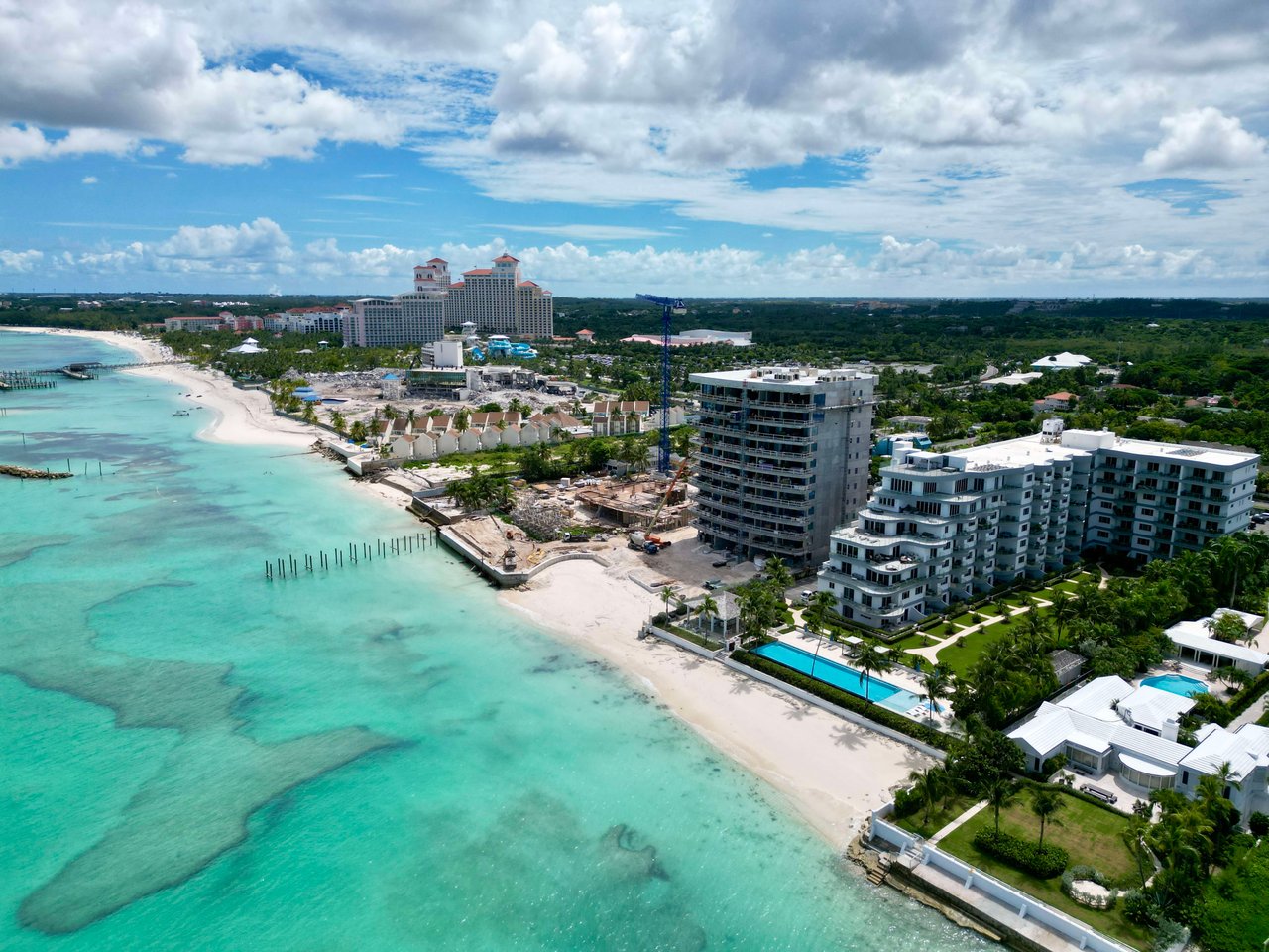 An aerial view of a beautiful beach with turquoise water lapping at the shore.