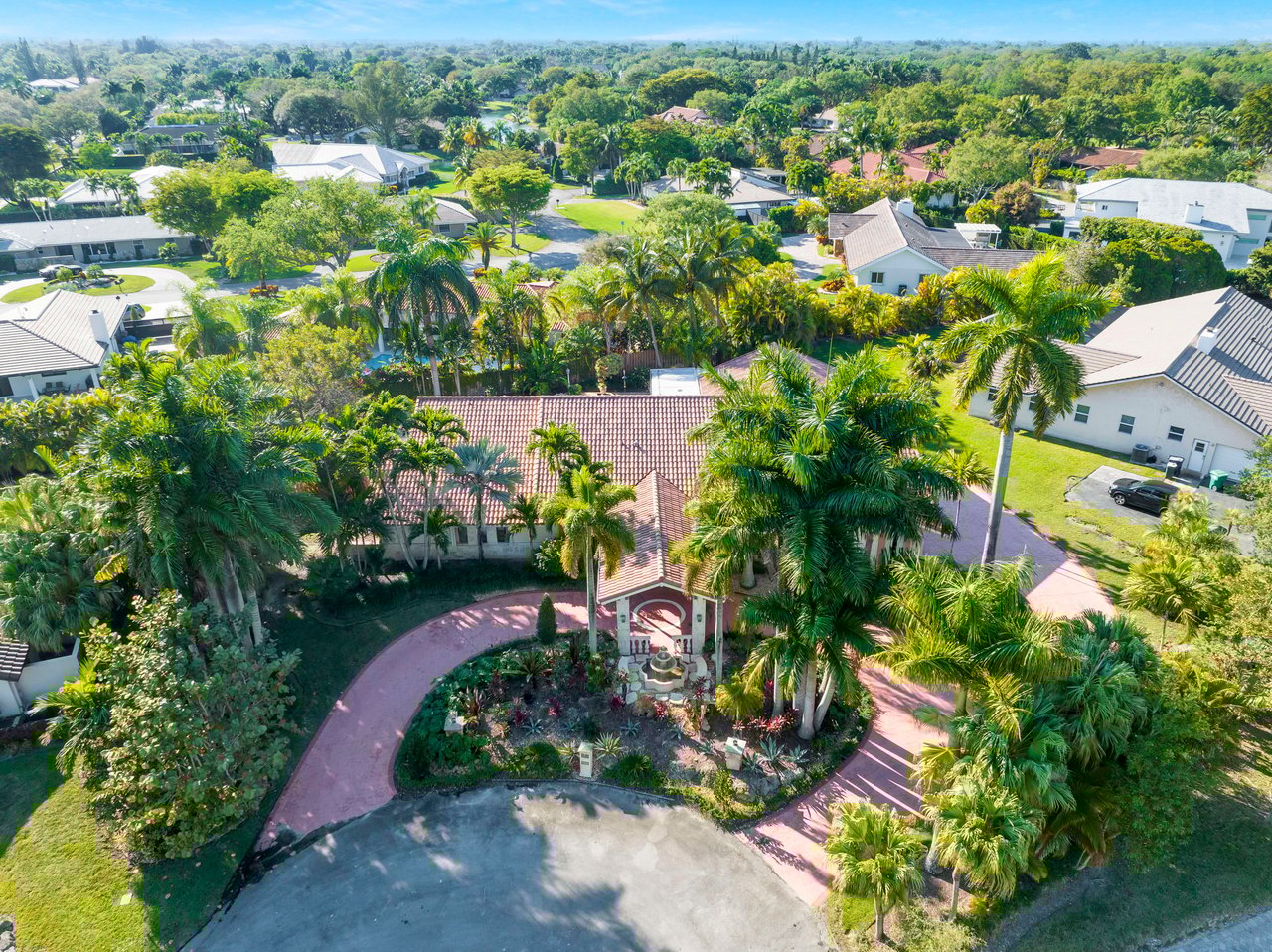  An aerial view captures a sprawling luxury home in a lush, green residential area