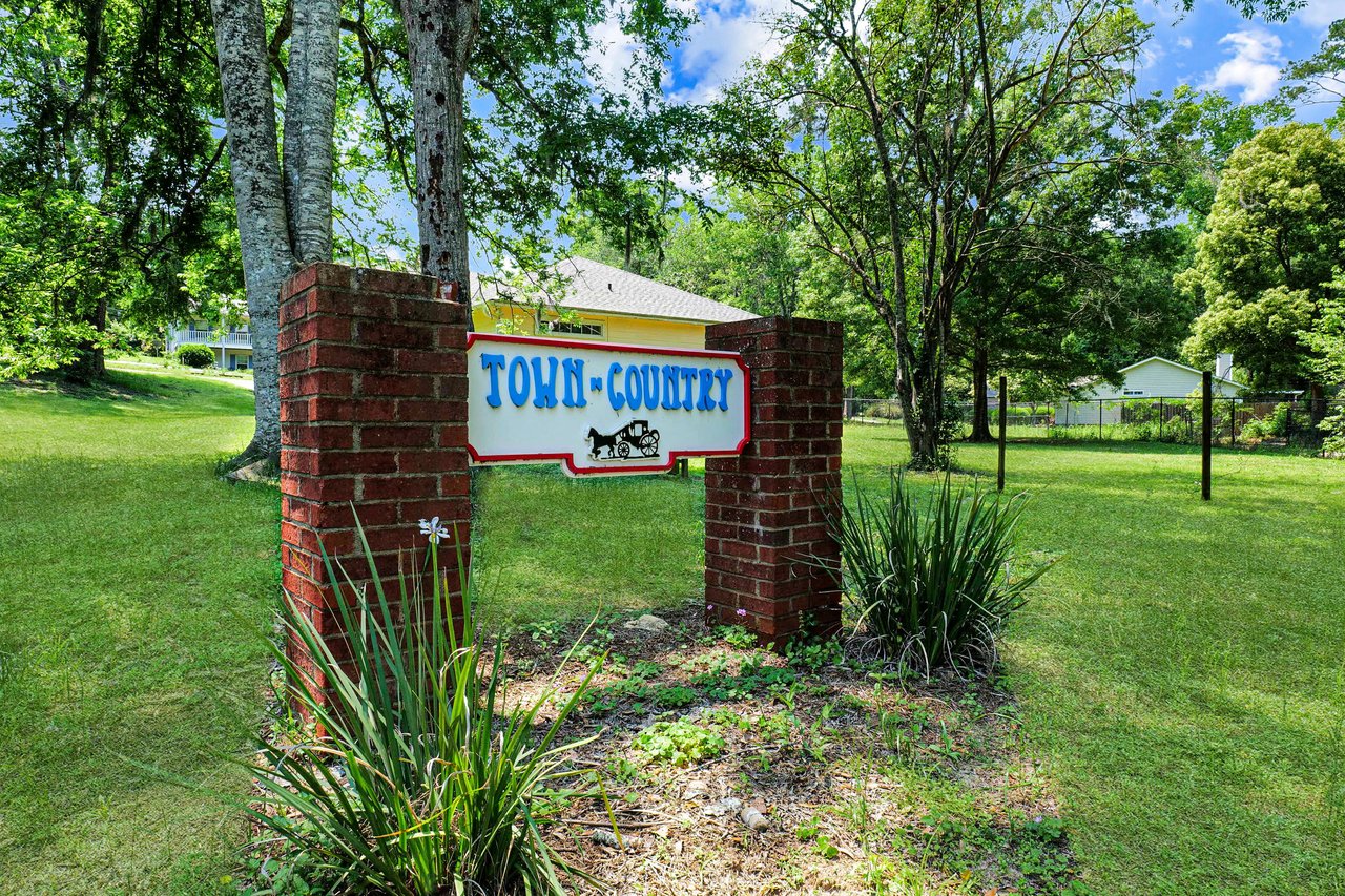 A ground-level view of the entrance sign for "Town and Country," indicating the name of the residential community.