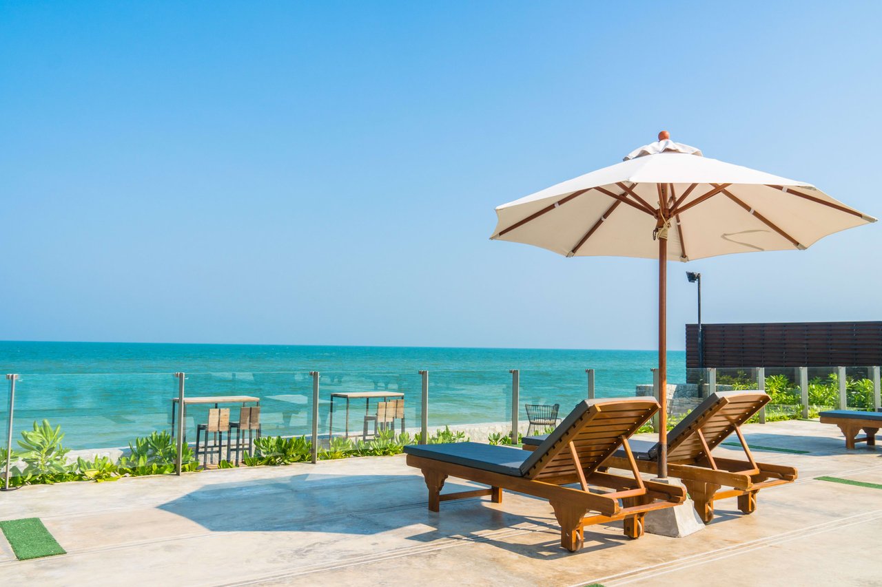 beautiful beach front with chair and umbrella