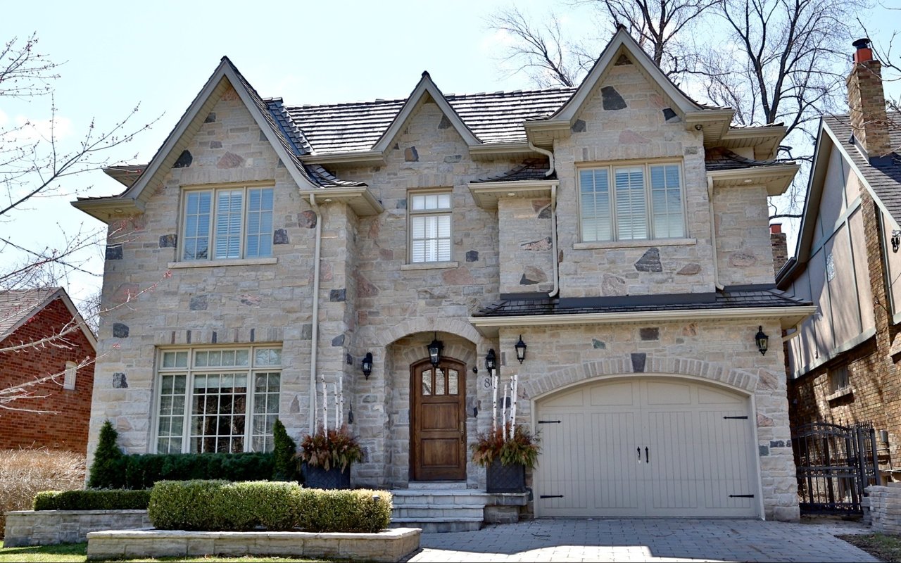 A large three-story stone house with a gabled roof and multiple windows