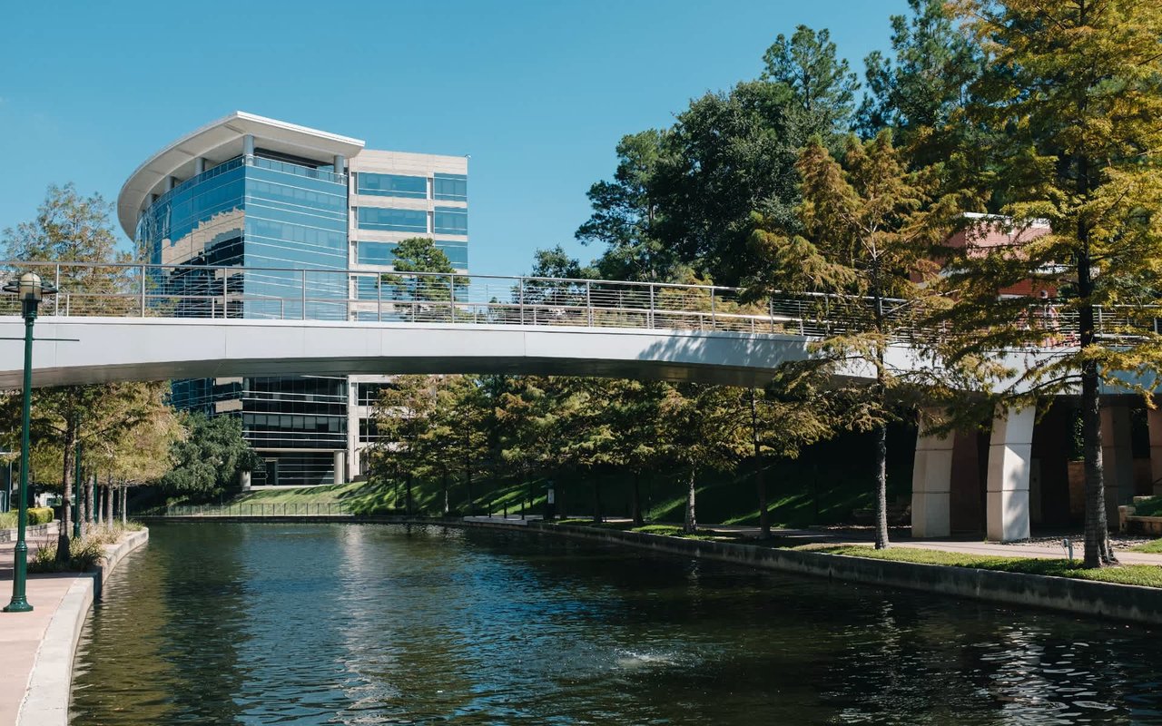  A tranquil urban canal flows between green, tree-lined banks