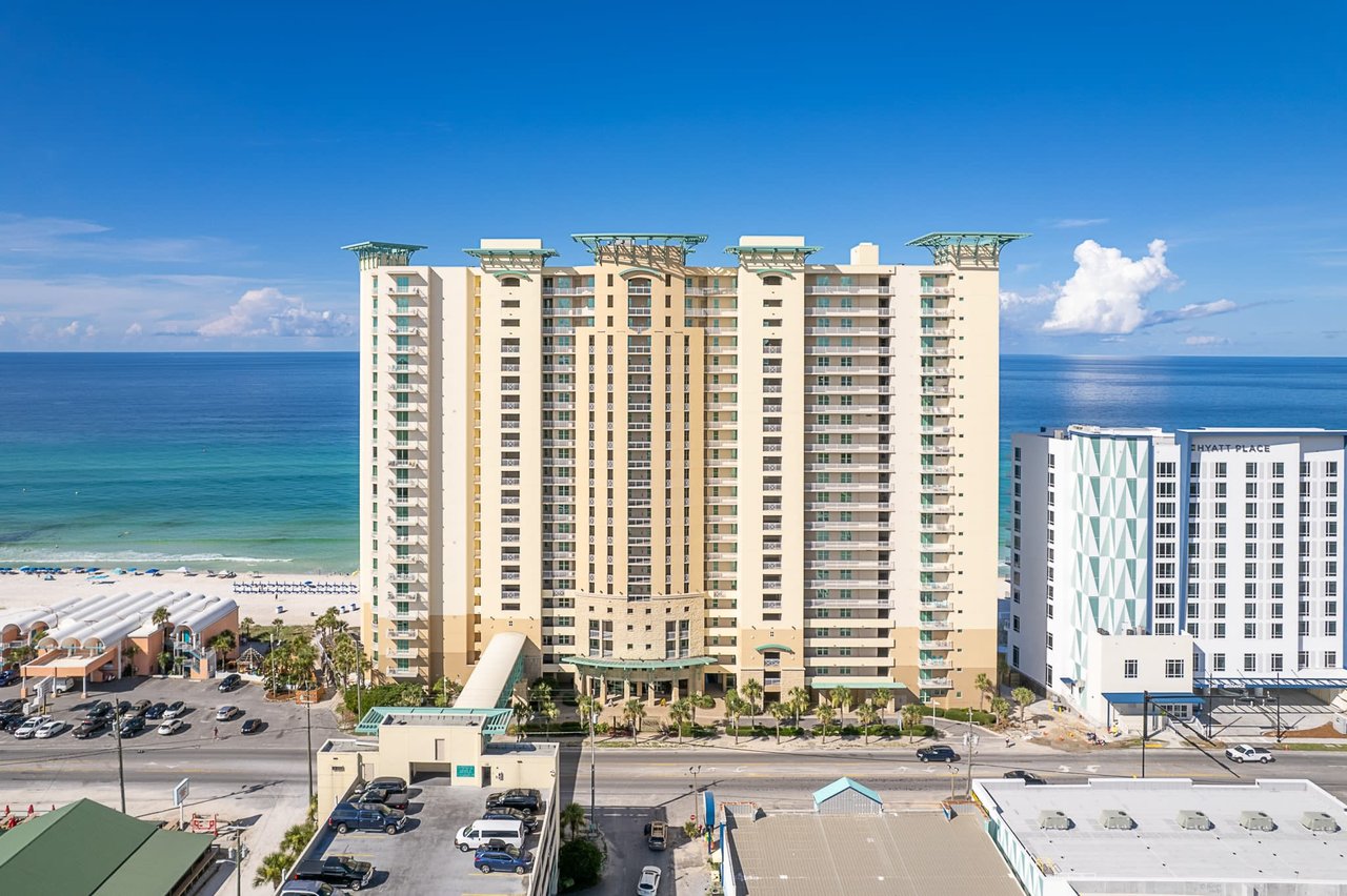 An aerial view of a large hotel complex next to a sandy beach.