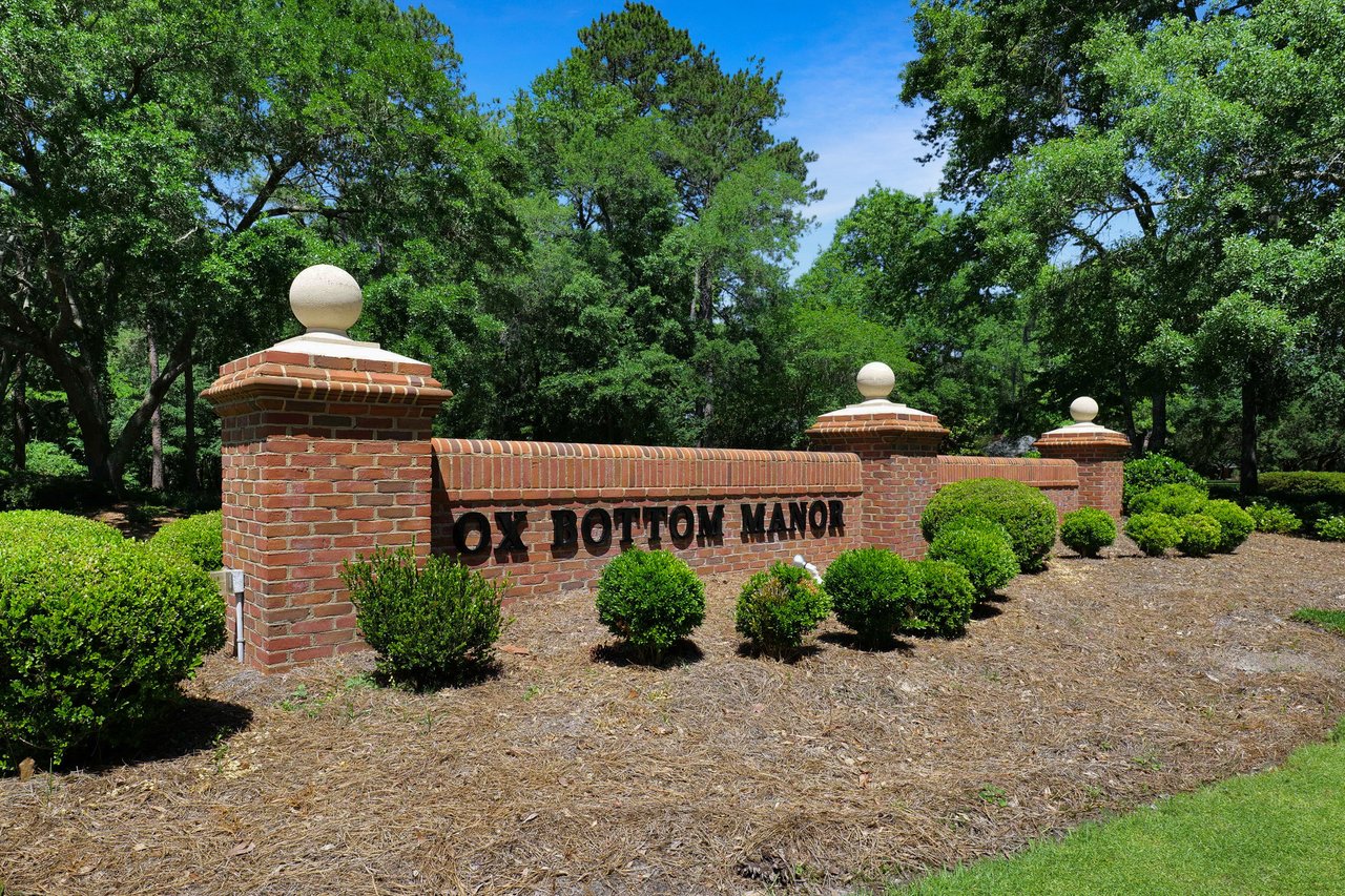 A ground-level view of the entrance sign for "Ox Bottom Manor," marking the entrance to the community.