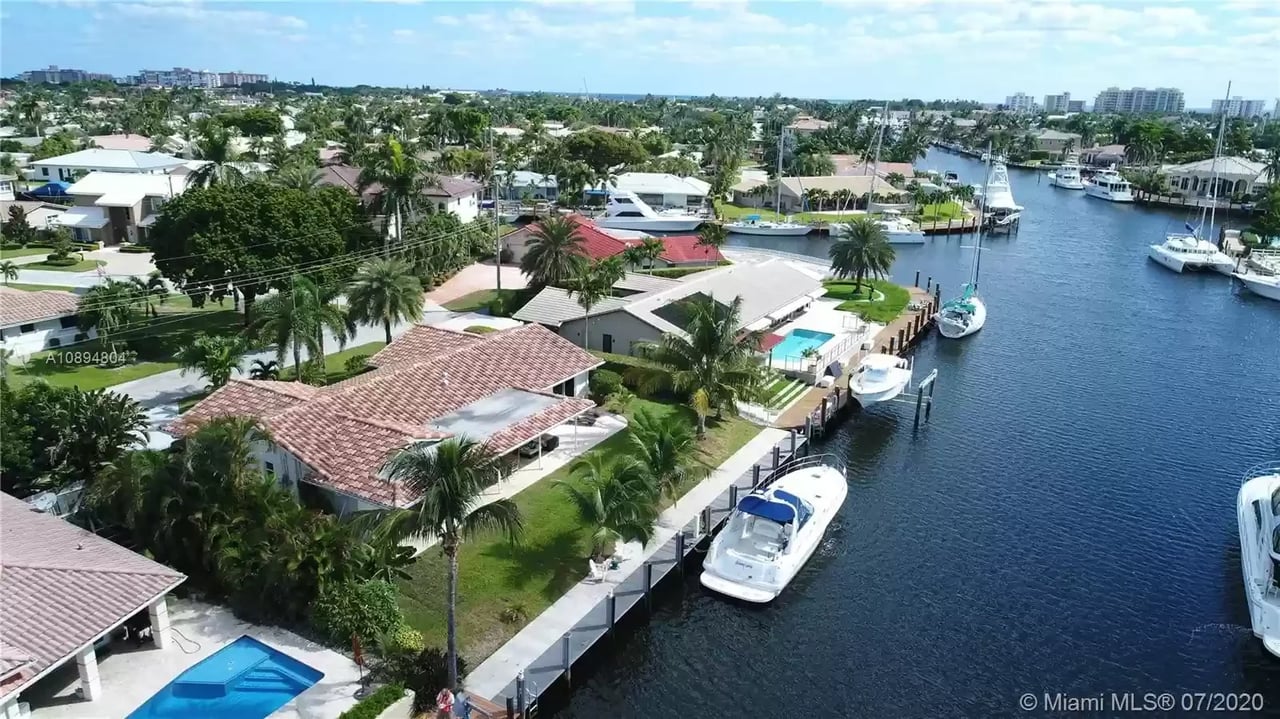 Tranquil mornings unveil a picturesque waterfront, with homes standing beside yachts, bathed in the golden sun's warm glow.