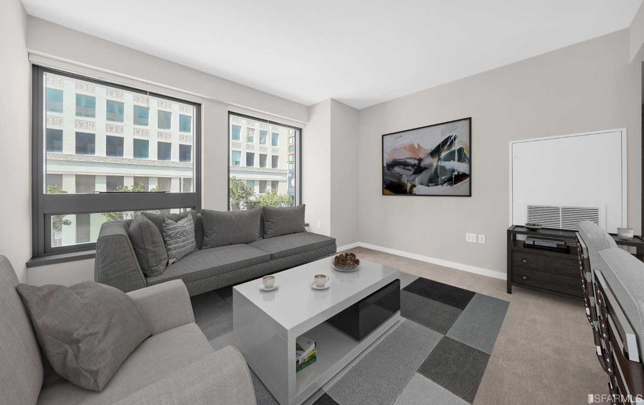 Modern living room inside a condominium at 1 Hawthorne Street, San Francisco, featuring sleek finishes, large windows, and an open-concept layout.