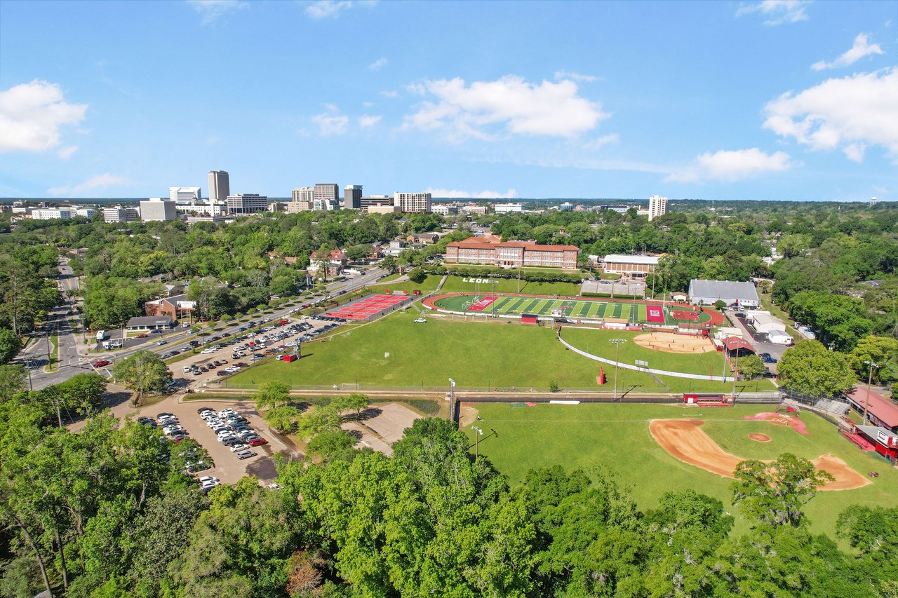 An aerial view of Old Town neighborhood with a sports field, possibly a school or community center, surrounded by residential houses and greenery.