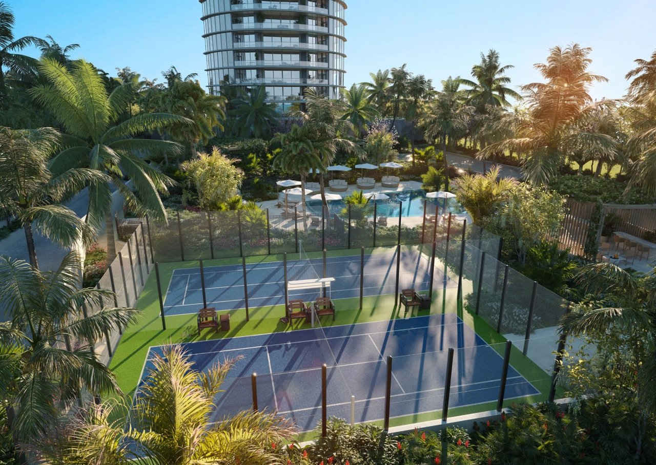 Rivage Bal Harbour tower above tropical grounds with tennis courts and a pool.