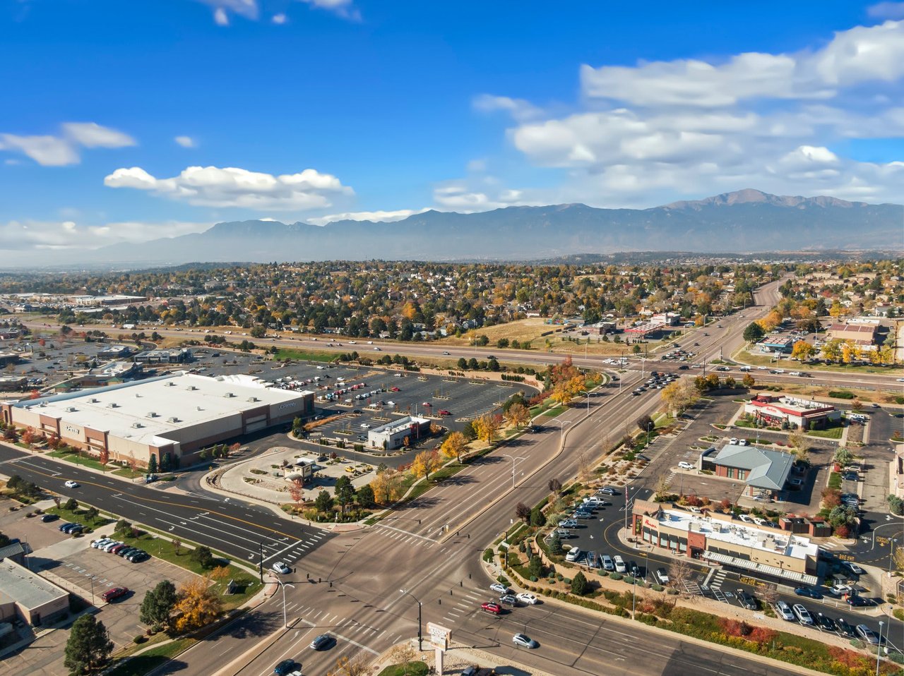 An aerial view of a bustling suburban area with a mix of residential and commercial buildings