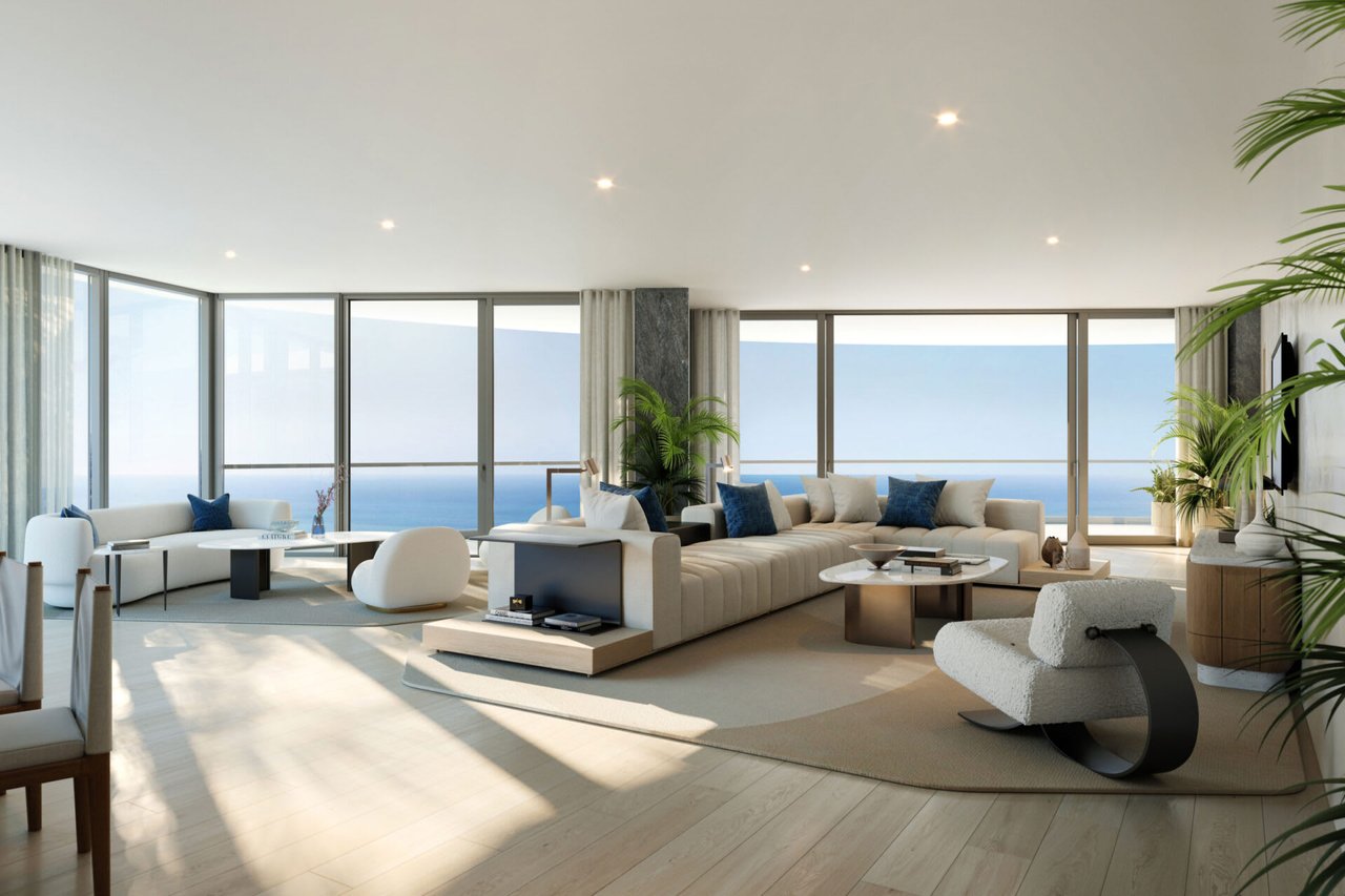 Furnished living room with floor-to-ceiling windows overlooking the ocean.