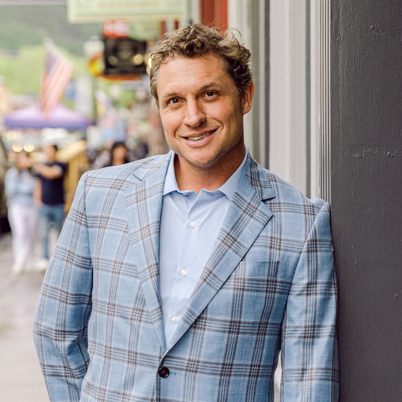 Andrew "Drufur" Williamson in light blue plaid blazer smiling in downtown Telluride, Colorado.