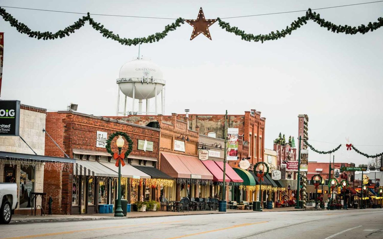 A row of shops decorated with Christmas lights and festive garlands in Grapevine Main Street.