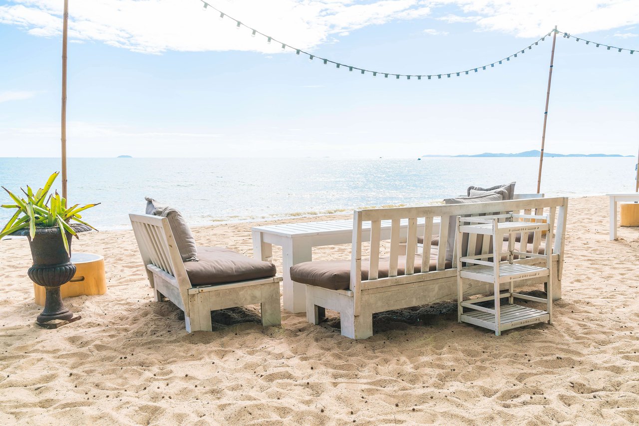 white chairs and table in the sand