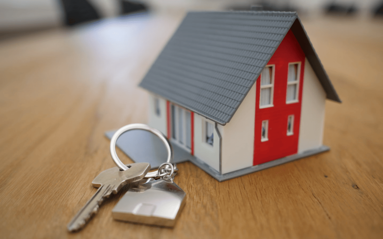 New homebuyer keys and house with red door 