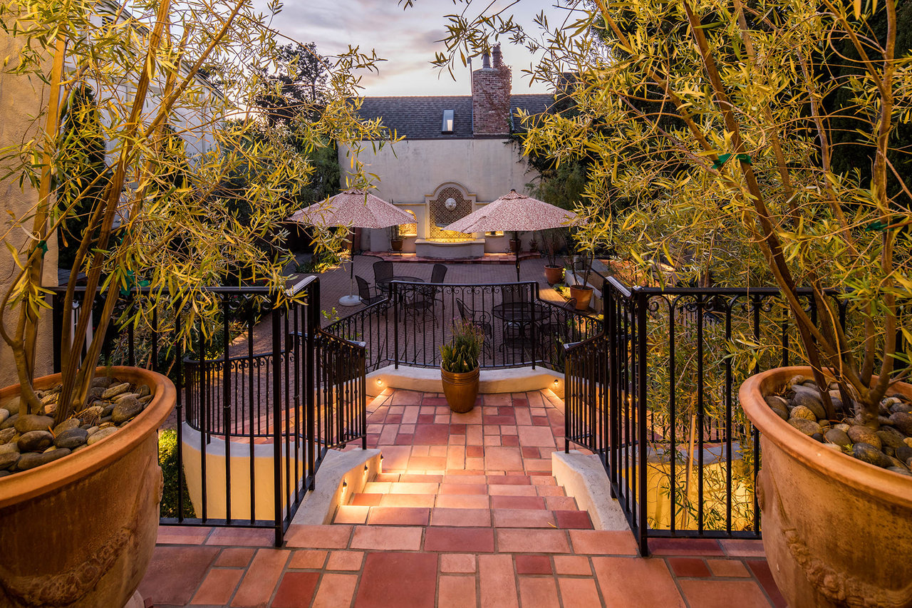 A patio area with umbrellas and a fence