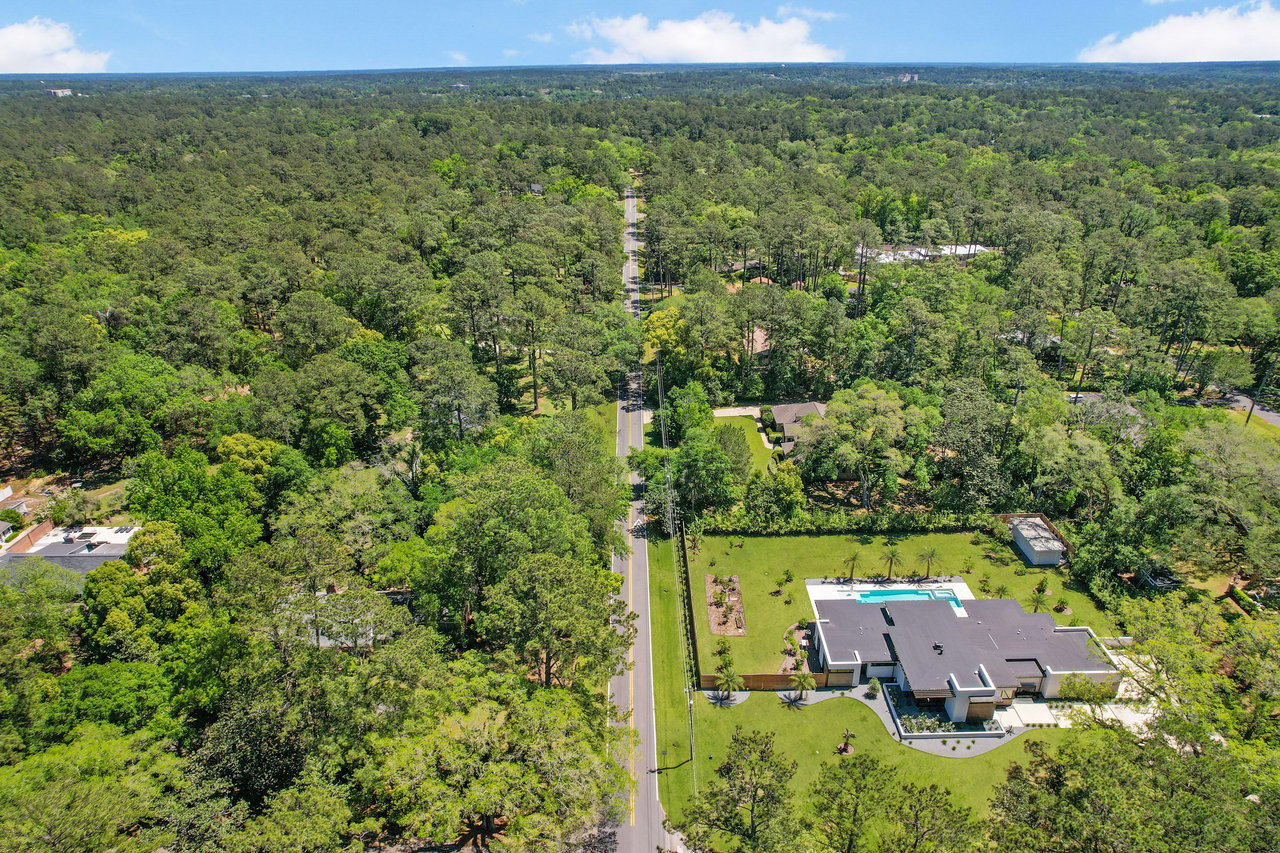 An aerial view of the Piedmont Live Oak neighborhood, showcasing houses, streets, and dense tree cover.