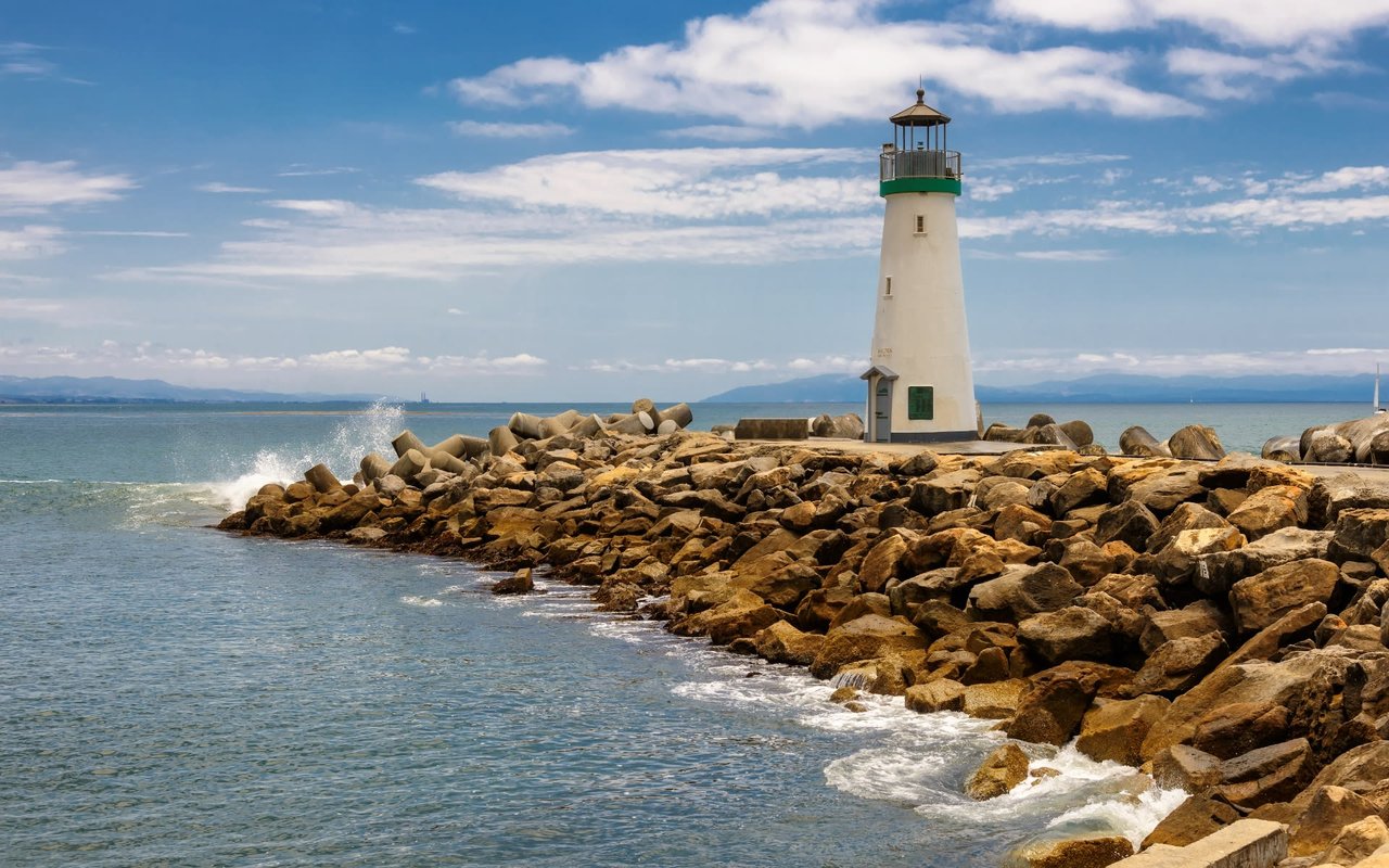 Santa Cruz Harbor Lighthouse on a rocky breakwater.