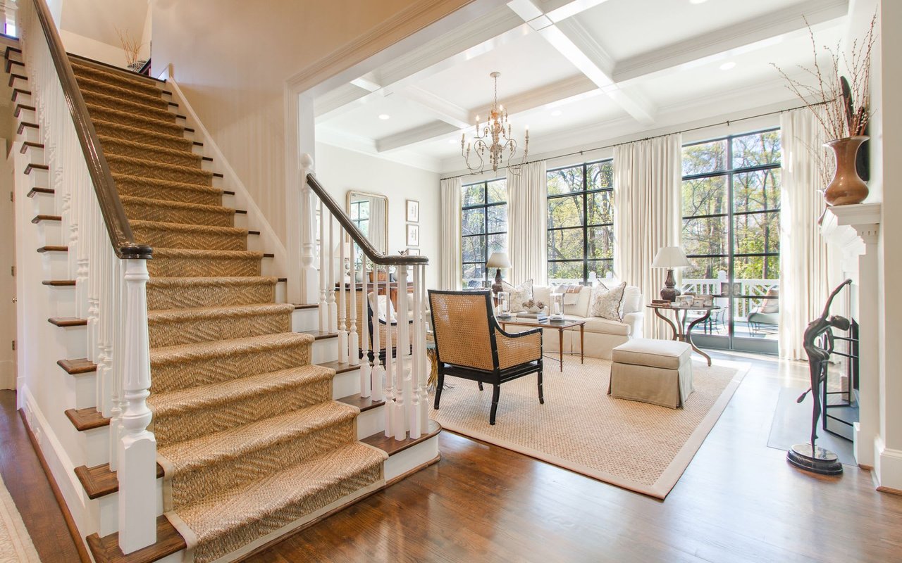  A staircase leading to a living room with a couch, chairs, and a fireplace