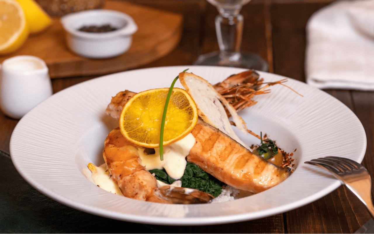  A beautifully plated seafood dish is presented on a white, ridged plate.