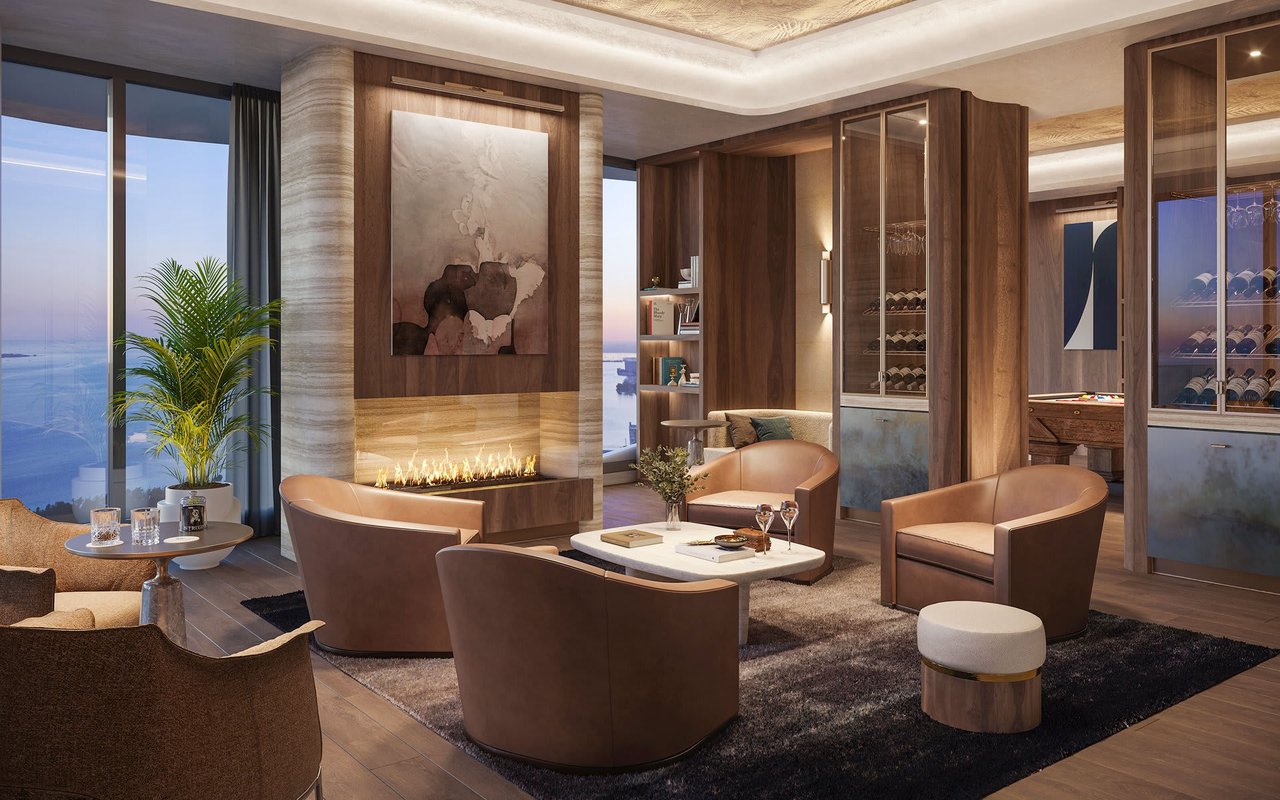 Luxury residence lounge with ocean views, a linear fireplace, and glass-front wine storage.