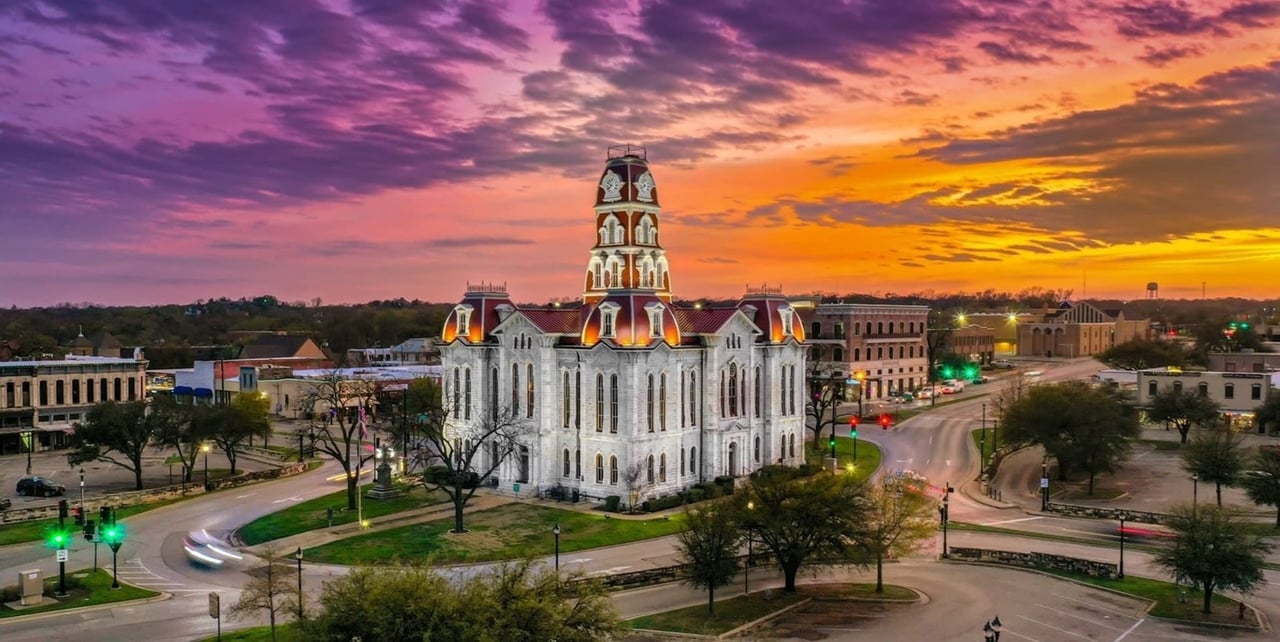 Tall white courthouse building on city square in Weatherford Texas at sunset