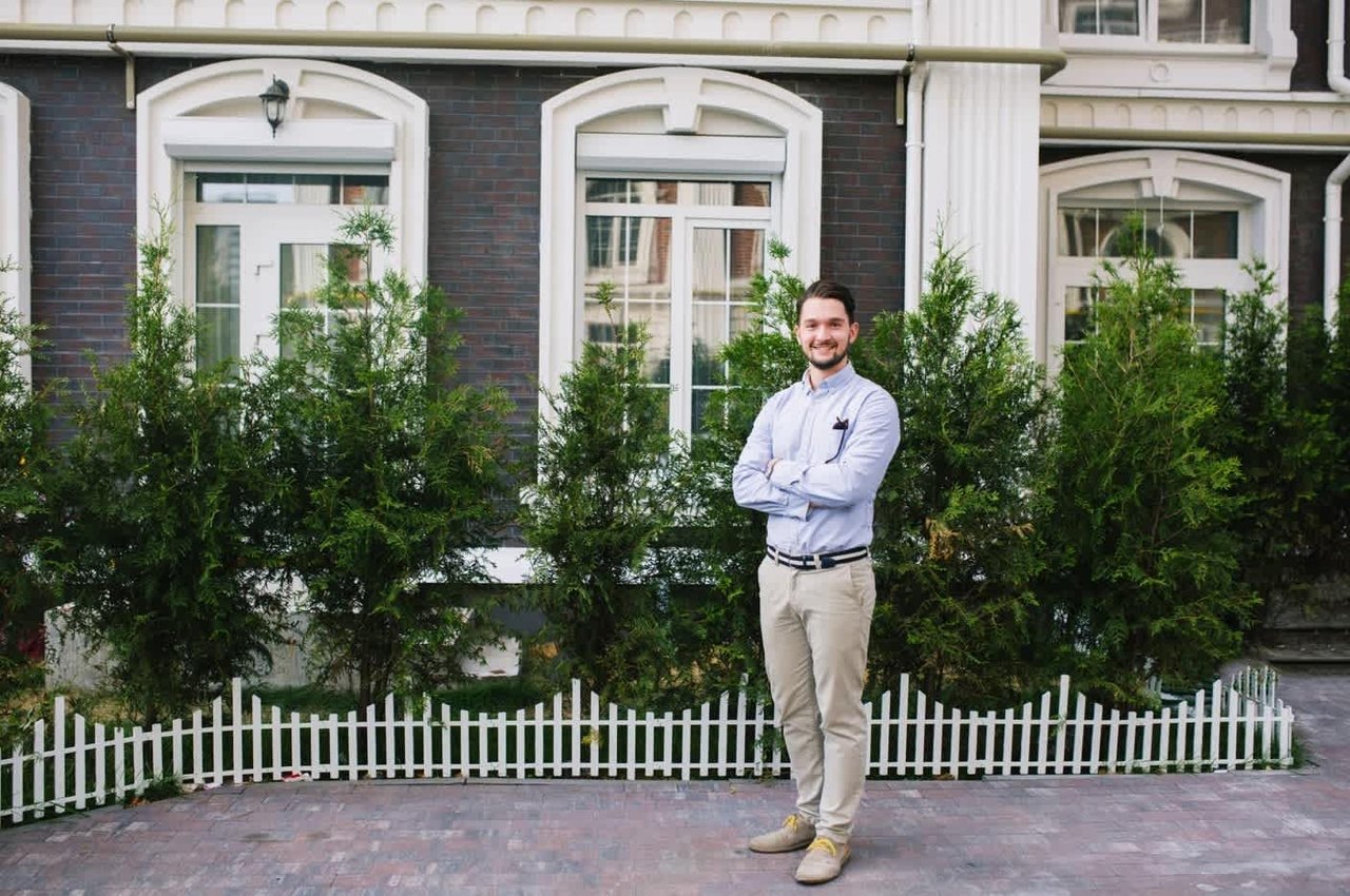 a man posing infront of a real estate unit