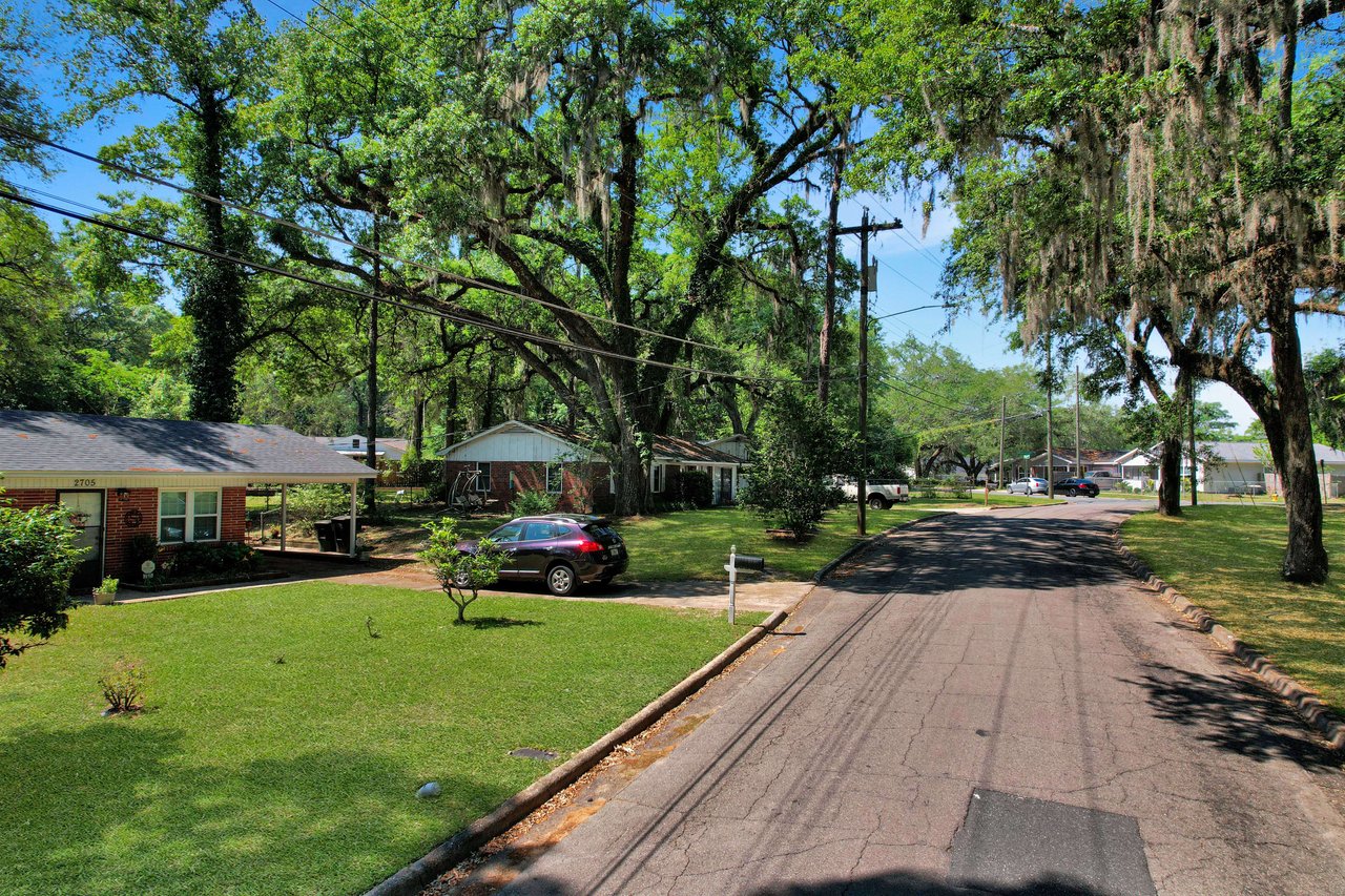 A closer view of a residential street with houses in Marby Park. The street is tree-lined and has a peaceful, suburban feel.