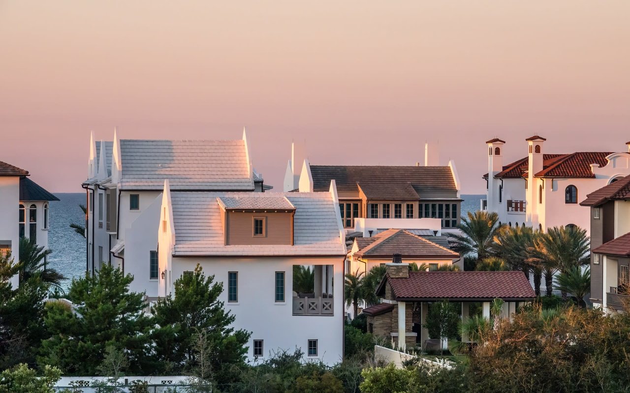 Oceanfront houses rest beneath the gentle hues of a calming twilight, creating a serene and picturesque evening ambiance.