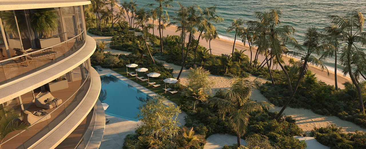 Curved beachfront residence overlooking a pool, palm-lined grounds, and ocean shoreline.