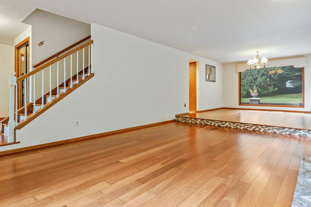 Enter to discover an elegant formal living room and dining room, showcasing beautiful Brazilian cherry flooring.