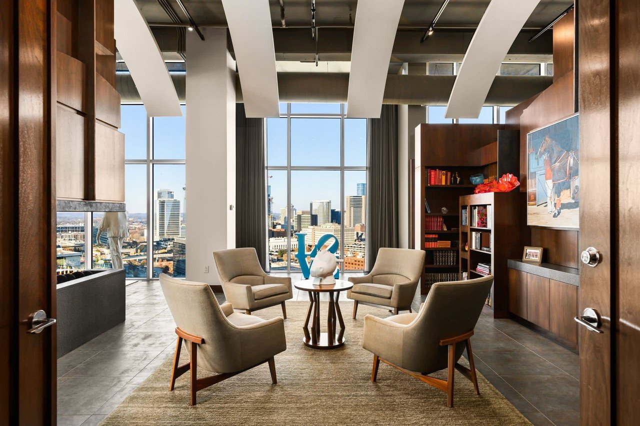 Spacious penthouse seating room in The Icon in the Gulch Nashville with modern furnishings and floor-to-ceiling windows.