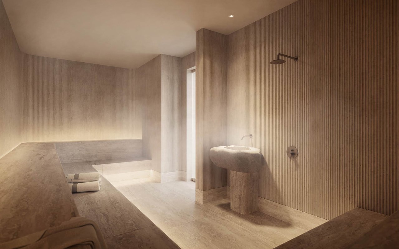Spa-like bathroom with a sculptural stone basin, ribbed walls, and built-in bench with folded towels.