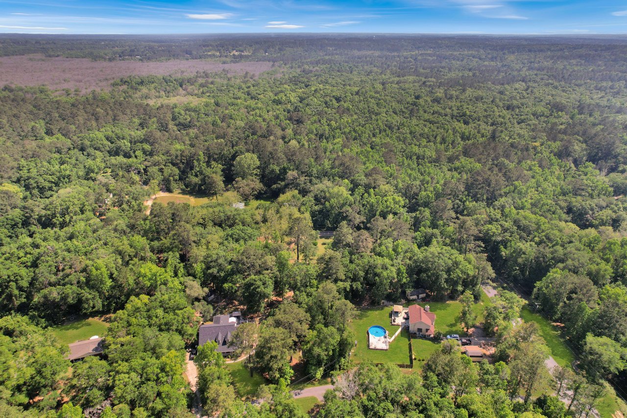 Aerial view of Miccosukee Land Cooperative showing more houses and roads within the Miccosukee Land Cooperative community, surrounded by forest.