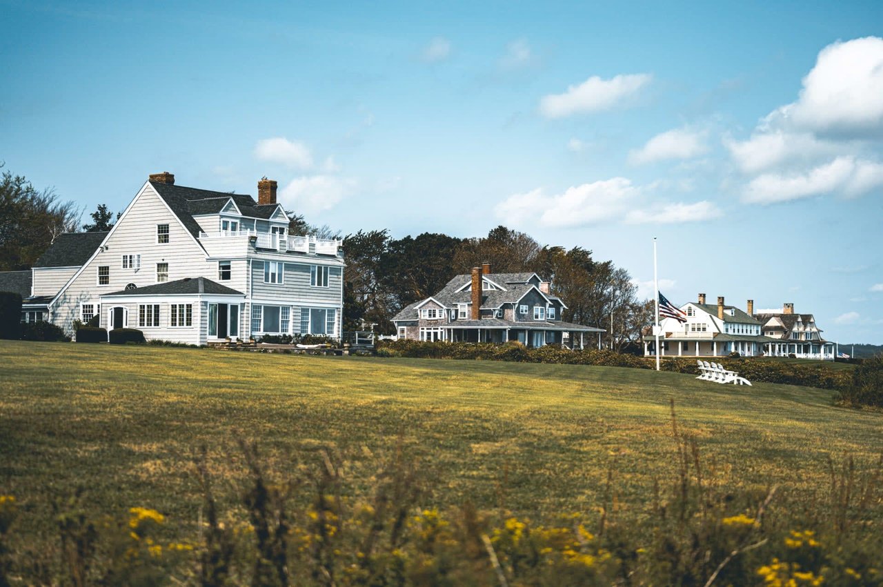 A cluster of vibrant houses adorns a verdant hillside in Riverside, Connecticut, boasting panoramic views of the town and its picturesque surroundings.