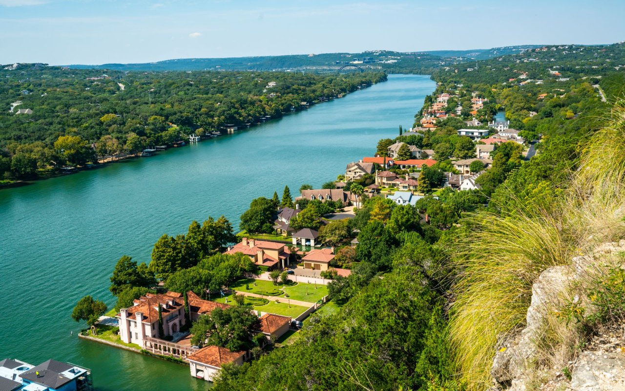 A bird's-eye view of a sparkling blue lake surrounded by verdant greenery.