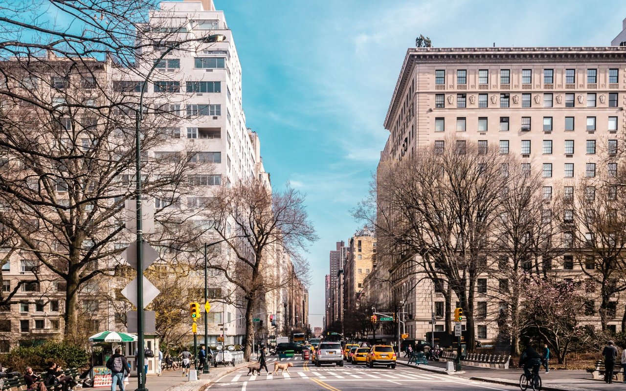 Busy city street with tall buildings and trees.