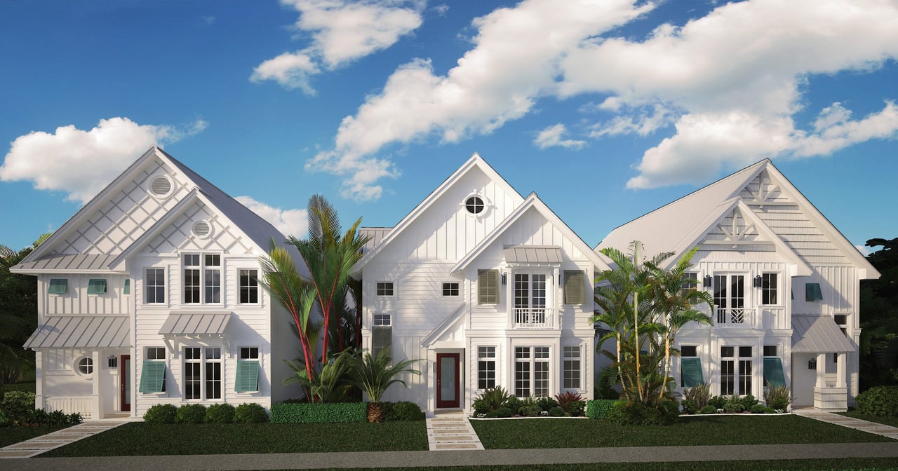 A row of three homes with white facades and neat lawns and blue sky with clouds in the background