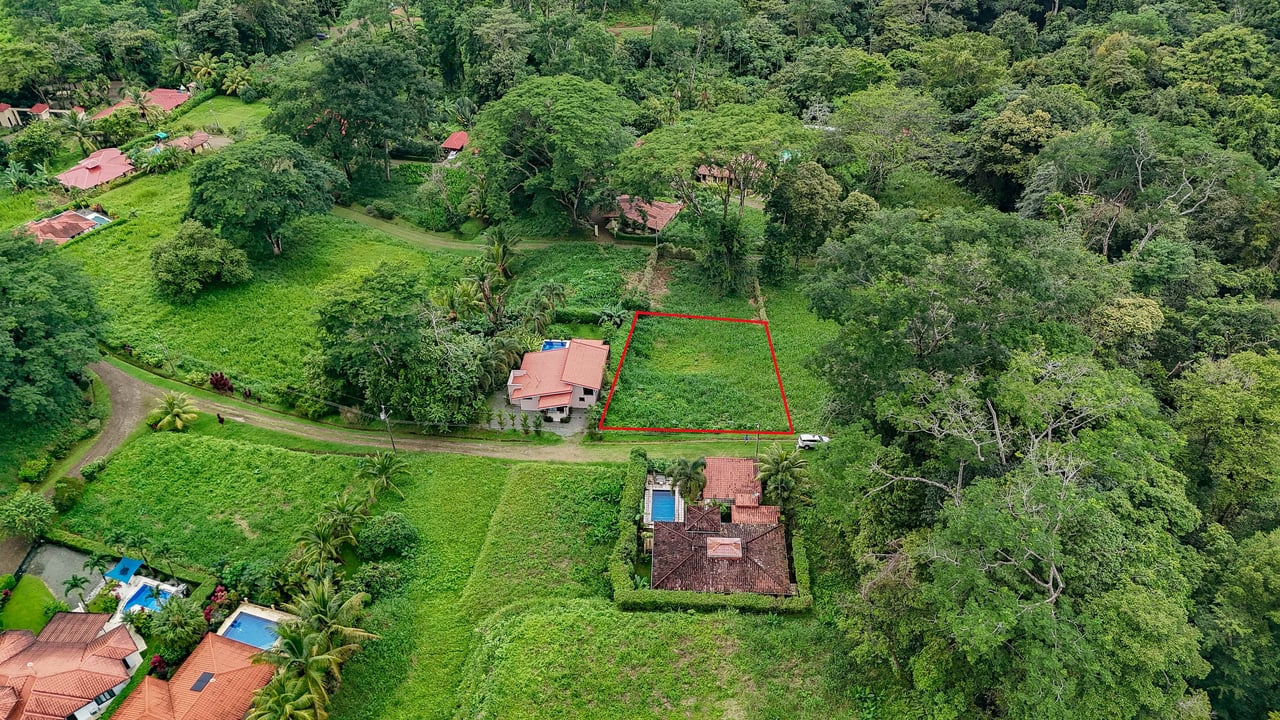 A beautiful sunny lot in a secure gated community with a nearby creek and jungle-covered valley.