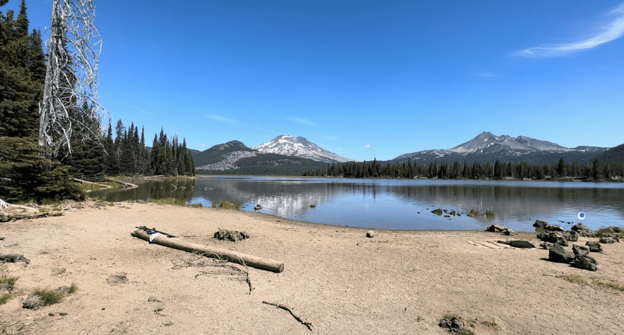 a beautiful lake surrounded by trees and mountain ranges