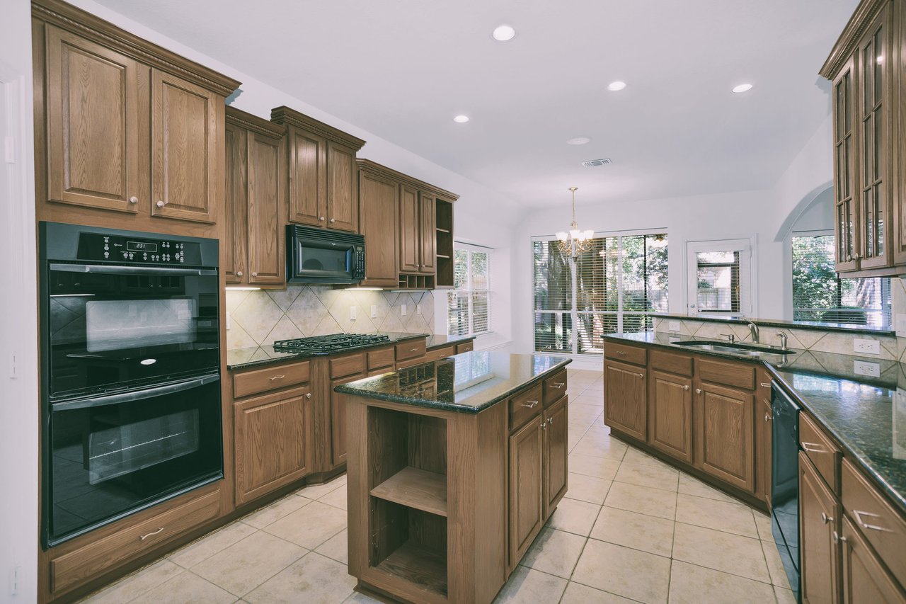 Kitchen with double ovens, gas cookstop, working island, and breakfast bar. Great cabinet space and a walk-in pantry!