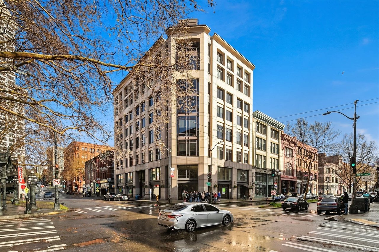 Corner view of a classic, elegant condo building at a bustling city intersection, embodying downtown luxury.