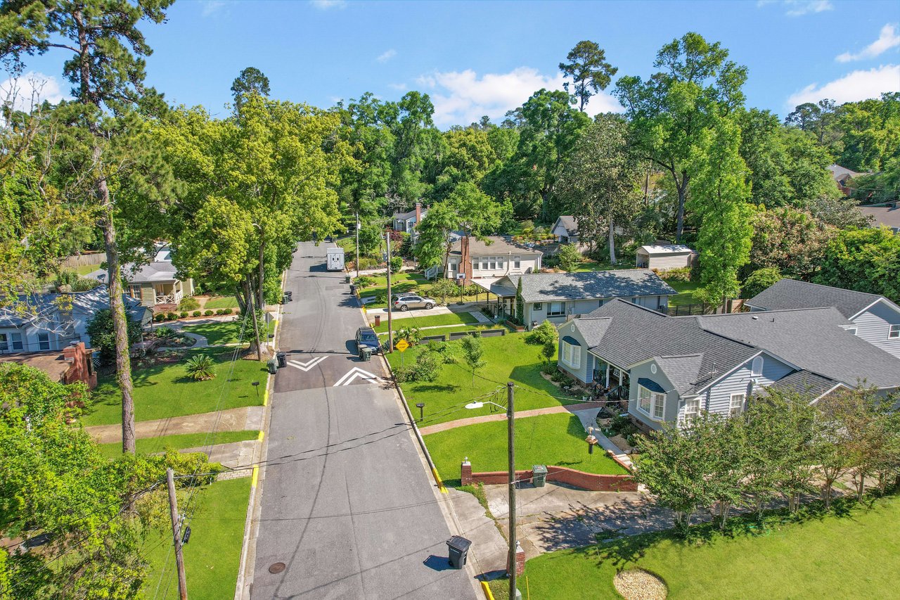 A street-level view of a residential neighborhood in Old Town, featuring houses, trees, and a road leading through the area.