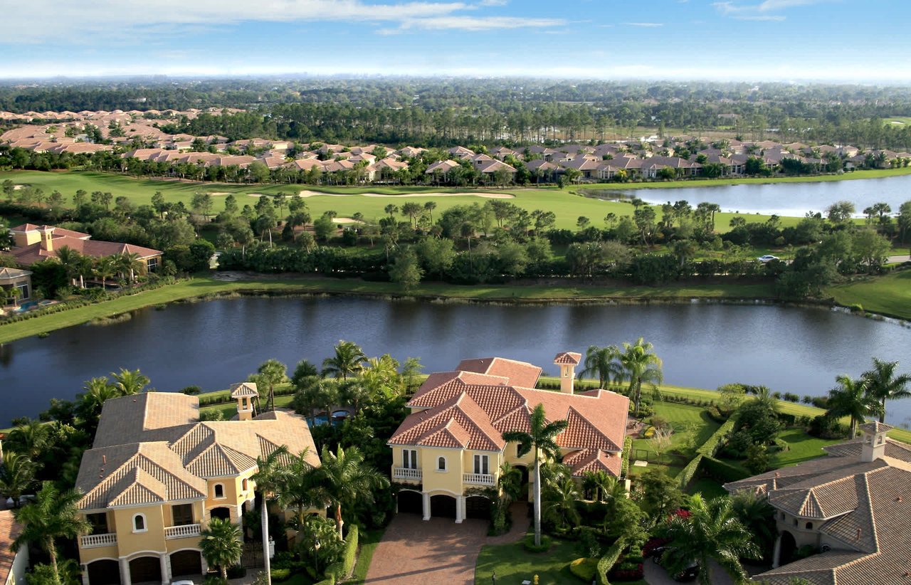 Aerial view of a golf course surrounded by houses and a lake