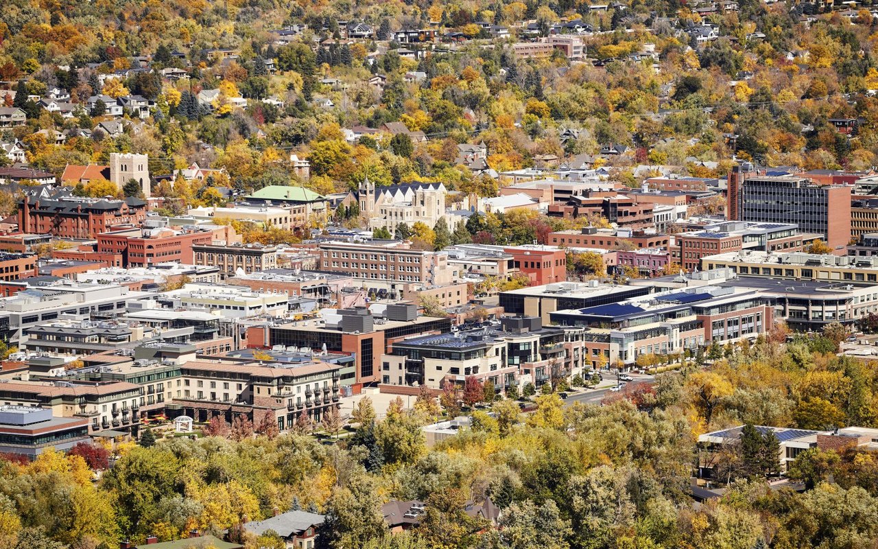 An aerial view of Boulder City, CO, in autumn, with a mix of buildings, parks, and gardens.