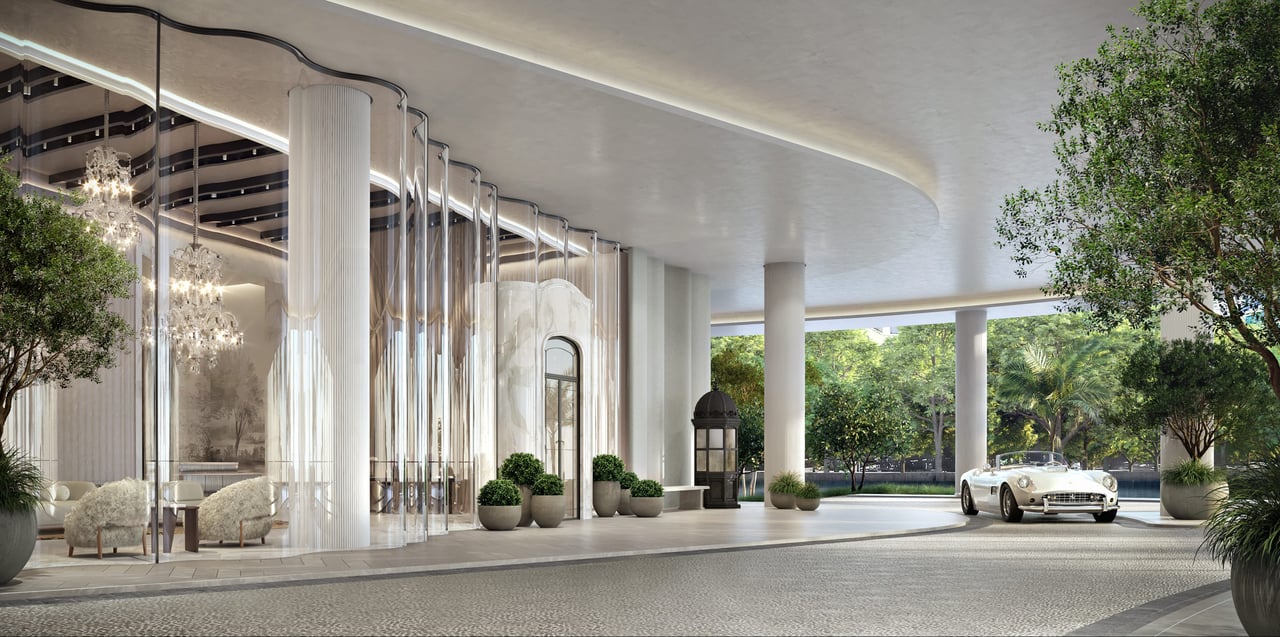 Baccarat entrance with a sweeping white canopy, glass lobby, and vintage convertible at the curb.