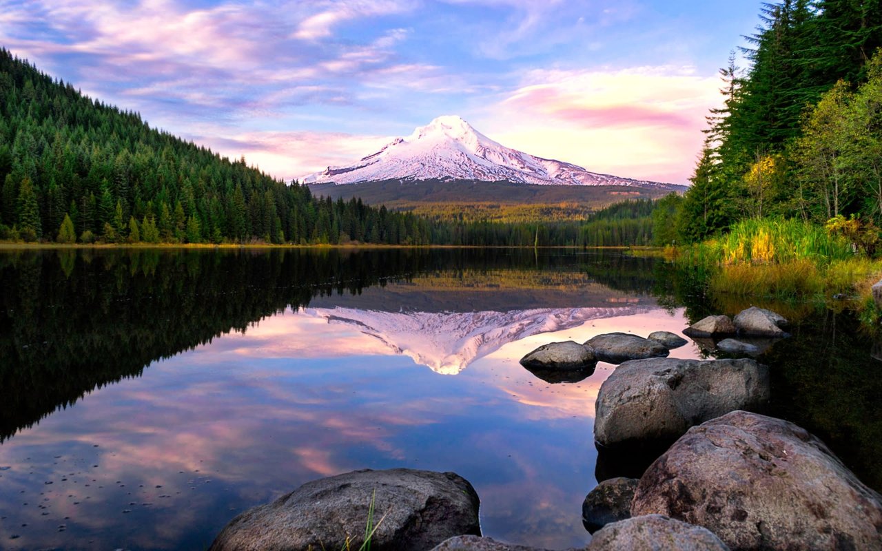 a clear majestic lake surrounded by trees overlooking a beautiful white top mountain